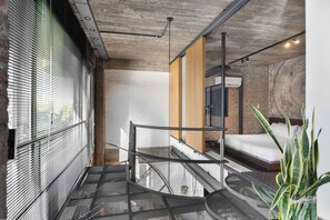 A modern interior with a staircase, a bed, and a plant. - Fabulous & stylish apartment in Palermo Hollywood (Buenos Aires)
