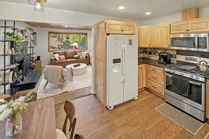 A modern kitchen with wooden cabinets, a stainless steel refrigerator, and a built-in oven. - Big Bear Cabin - Hot Tub, Fire Pit, Pet-Friendly - 2 Min to Bear Mountain (Big Bear Lake)