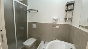 Un baño con inodoro, bidé y bañera.