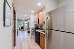 A modern kitchen with stainless steel appliances, wooden cabinets, and a view to the outside. - Bend Adventure Starts Here - Near Mt Bachelor (Bend)