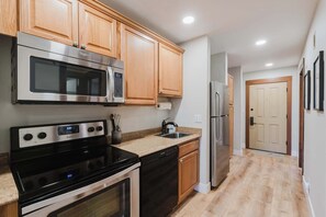 A kitchen with wooden cabinets, stainless steel appliances, and a granite countertop. - Bend Adventure Starts Here - Near Mt Bachelor (Bend)
