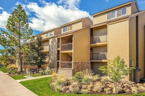 A multi-story residential building with balconies, a landscaped garden, and a clear sky. - Bend Adventure Starts Here - Near Mt Bachelor (Bend)