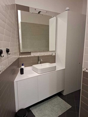A bathroom with a white sink, a mirror, and a towel rack. - ALICJA HOUSE (Casoria)