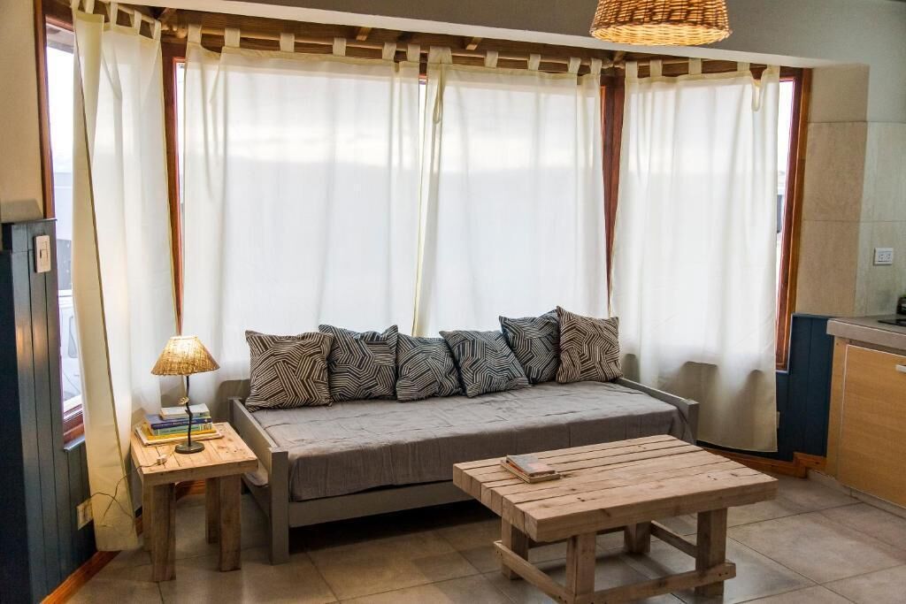 A cozy living area with a sofa, a small table, and a lamp.