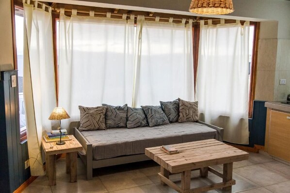A cozy living area with a sofa, a small table, and a lamp.