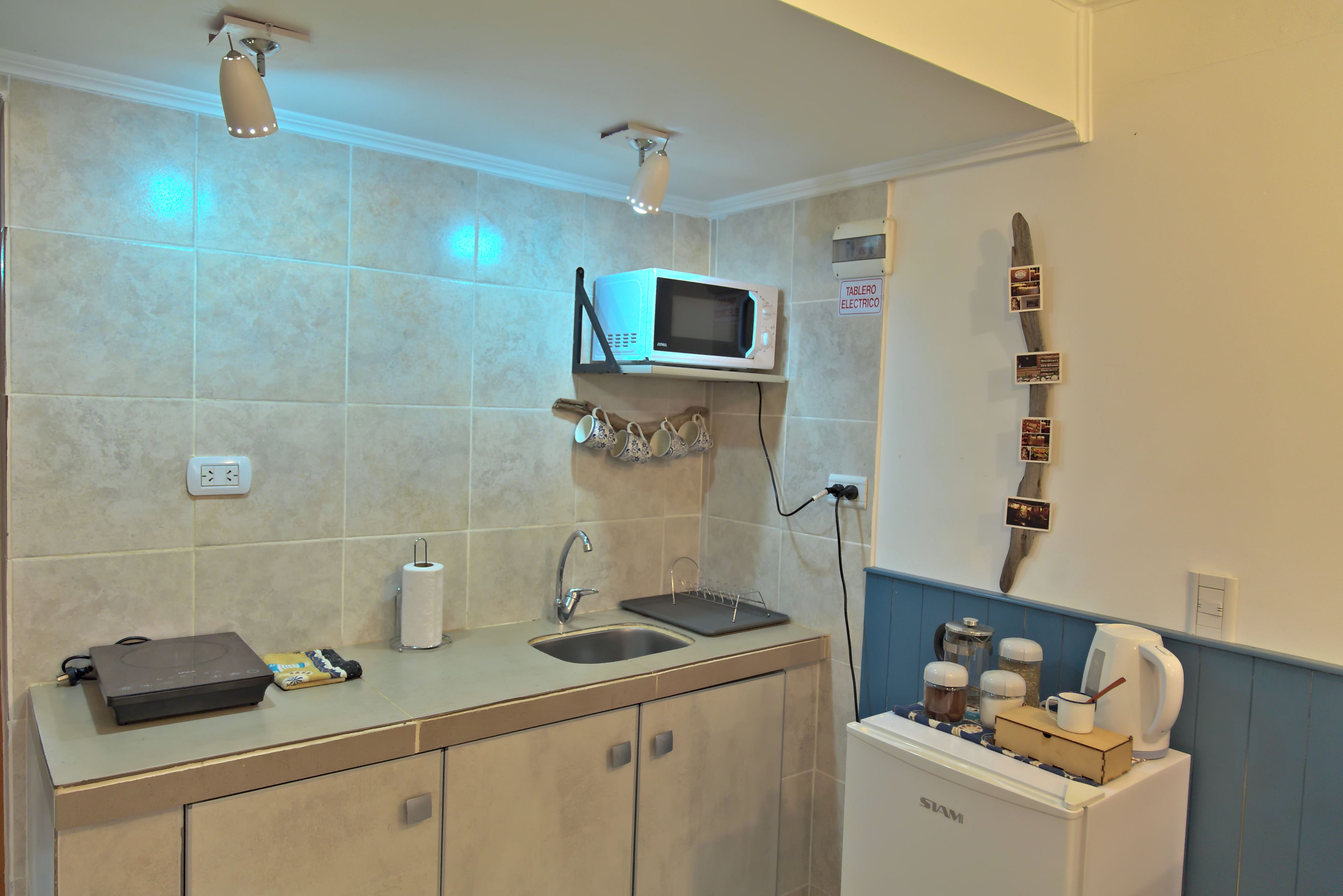 A compact kitchen with a microwave, sink, and countertop.