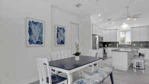 A modern kitchen with white cabinetry, stainless steel appliances, and a central island. - Coco Plum Getaway - Dockage -short walk to Coco Plum Beach - Brand New Home! (Marathon)