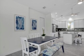 A modern kitchen with white cabinetry, stainless steel appliances, and a central island. - Coco Plum Getaway - Dockage -short walk to Coco Plum Beach - Brand New Home! (Marathon)
