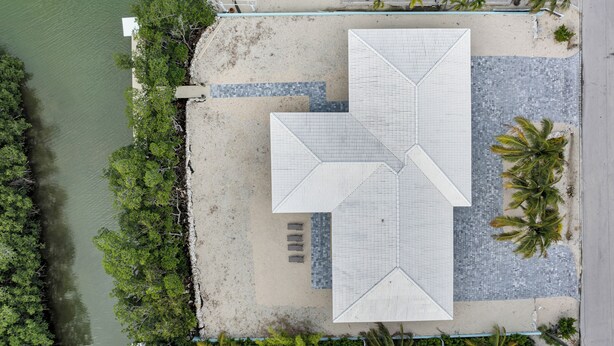 An aerial view of a beachside property with a large open patio, a pool, and a boat dock. - Coco Plum Getaway - Dockage -short walk to Coco Plum Beach - Brand New Home! (Marathon)
