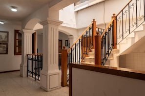 A staircase with wooden balusters and black metal railings, leading to an upper level.