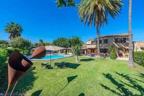 A pool with lounge chairs, a large palm tree, and a stone building with a tiled roof. - Pollensa Country Villa for 6 (Pollença)