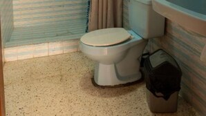Un baño con ducha, inodoro, lavabo y toallero.