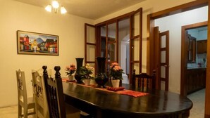 A dining area with a round table, chairs, and a painting on the wall. - Casa Cielo Antigua - Double Room with Private Bathroom (Antigua Guatemala)