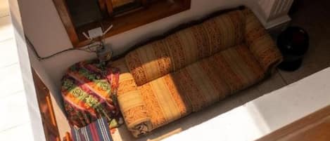 A room with a sofa, a window, and a radiator.