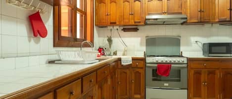 A kitchen with wooden cabinets, a stainless steel stove, and a microwave.