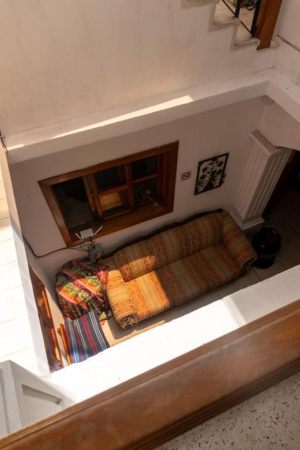 Ein Zimmer mit einer Couch, einem Fenster und einer Heizung.