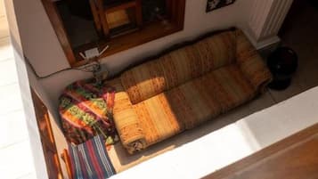 A room with a sofa, a window, and a radiator.