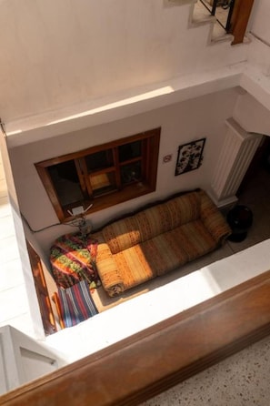 A room with a sofa, a window, and a radiator.