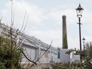 Ein Gebäude mit einem Metallzaun, einem hohen Schornstein und einer Straßenlaterne.