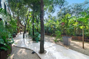 A concrete pathway surrounded by dense tropical vegetation and a wooden fence. - 4BR Luxury Villa w/ Pool & Heated Jacuzzi +Staff @ BlueDeerTulum (Tulum)