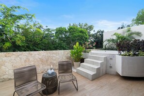 An outdoor patio with two wicker chairs, a small round table, a bottle of champagne, and a potted plant. - 4BR Luxury Villa w/ Pool & Heated Jacuzzi +Staff @ BlueDeerTulum (Tulum)