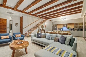 A modern living room with a staircase, a dining area, and a kitchen. - 4BR Luxury Villa w/ Pool & Heated Jacuzzi +Staff @ BlueDeerTulum (Tulum)