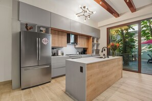 A modern kitchen with stainless steel appliances, wooden cabinets, and a central island. - 4BR Luxury Villa w/ Pool & Heated Jacuzzi +Staff @ BlueDeerTulum (Tulum)
