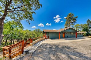 A building with a porch, a wooden fence, and a gravel driveway. - Amigos Nest (Alto)