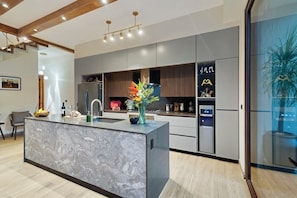 A modern kitchen with a marble island, stainless steel appliances, and a large window with a view. - LUX 4BR/4.5 Bath Jungle Villa - Private Pool+Jacuzzi+Staff - BLUE DEER TULUM (Tulum)