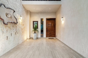 Un interior moderno con una pared de piedra, una puerta de madera y una planta en maceta.