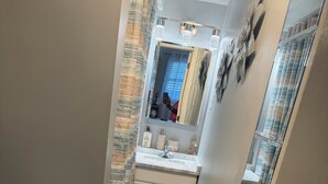 Een badkamer met toilet, wastafel en douche.