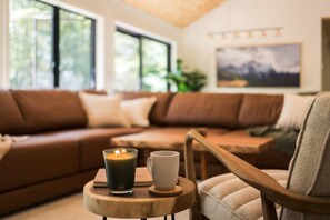 Sink into plush seating in this sun-drenched living room, where natural light streams through large windows and you can unwind with your morning coffee on the inviting sectional. - Casa Vetta | Modern Cabin with Fire Pit Near Davis (Davis)