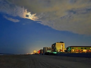 A beachside hotel with multiple buildings, a sandy beach, and a cloudy sky. - Complex With Lots of Amenities and Across the street from Beach (Daytona Beach)