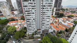 A high-rise building with multiple balconies, surrounded by a mix of residential and commercial buildings. - ON Vila Madalena (São Paulo)