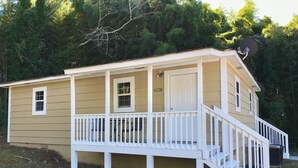 A two-story house with a front porch, a satellite dish, and a mailbox.