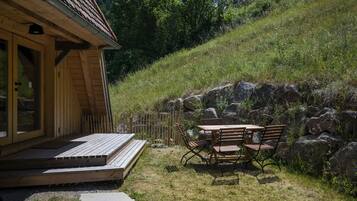 Eine Holzhütte mit Veranda, Tisch und Stühlen.