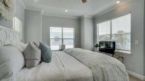Ein Schlafzimmer mit einem Bett, einem Fernseher und einem Fenster mit Jalousien.