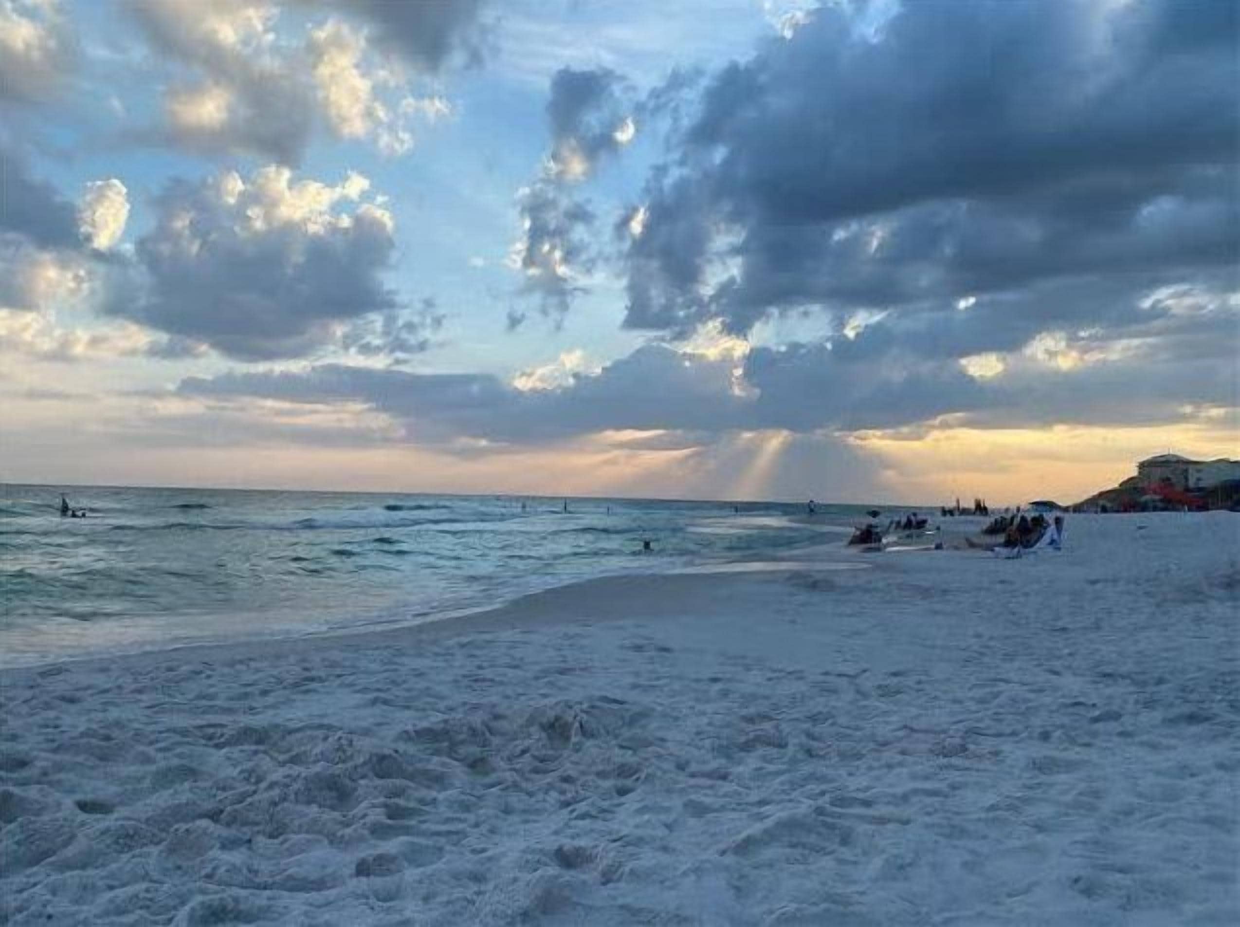 A beach with waves and a cloudy sky.