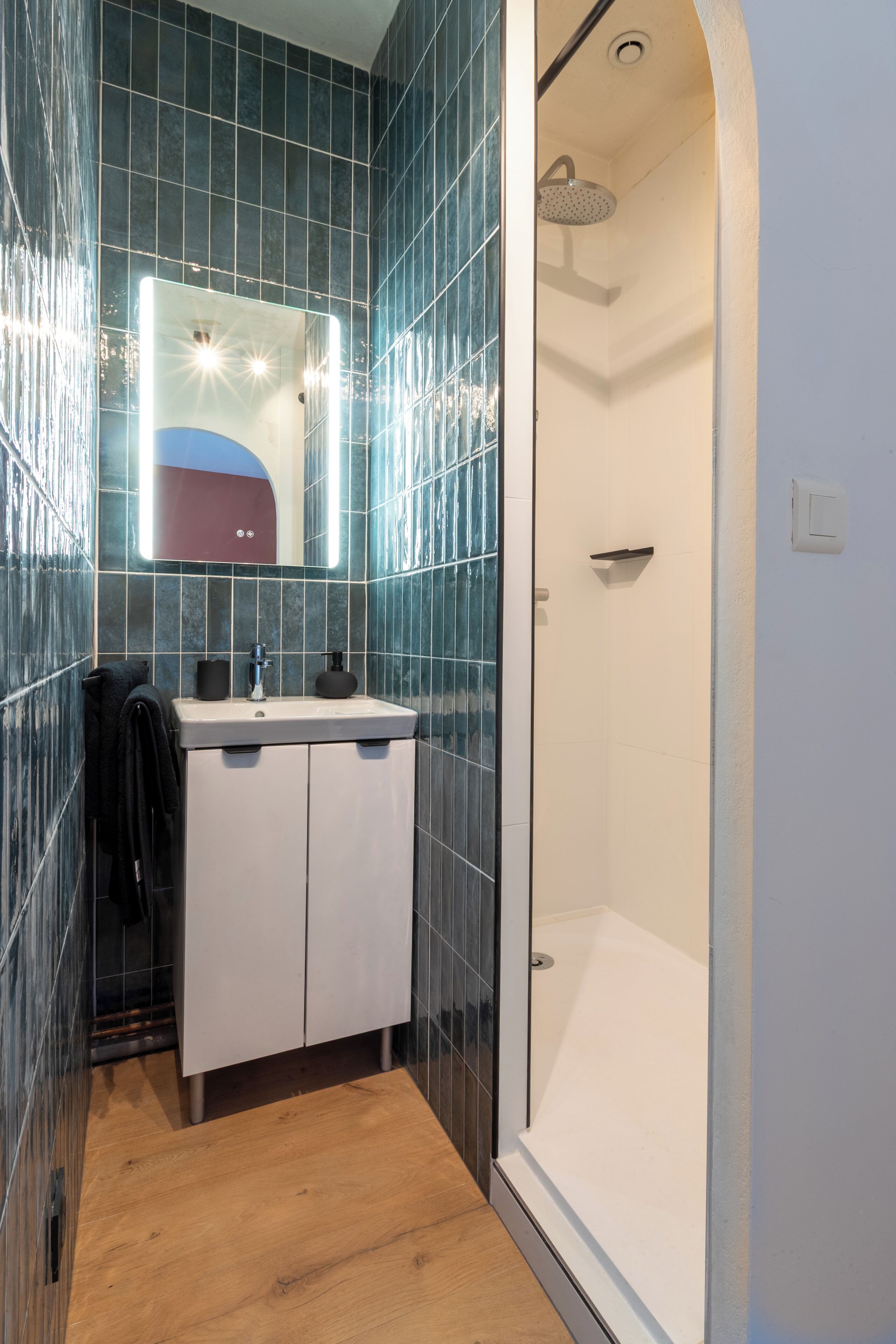 A bathroom with a shower, a sink, and a mirror.