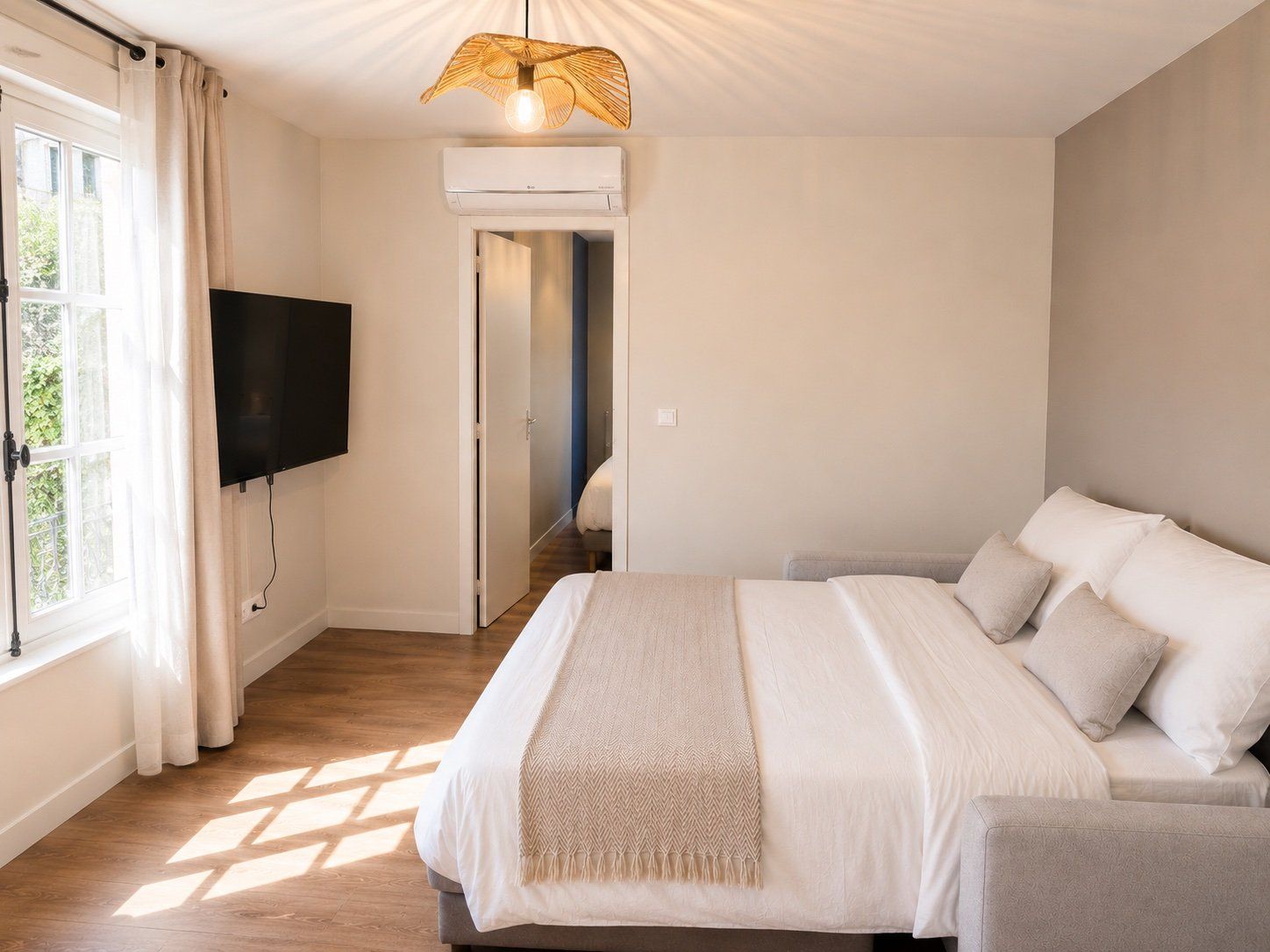 Un dormitorio con cama, televisión y aire acondicionado.