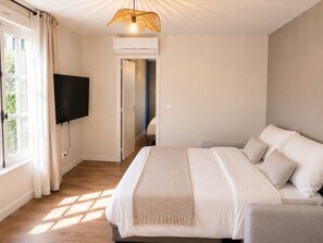 A bedroom with a bed, a television, and an air conditioning unit. - Diane – Cocon avec climatisation (Poitiers)