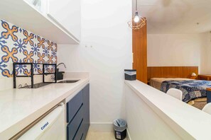 A compact kitchen with a white countertop, a sink, and a patterned backsplash. - Studio pr Ximo da Paulista Metr e Masp (São Paulo)