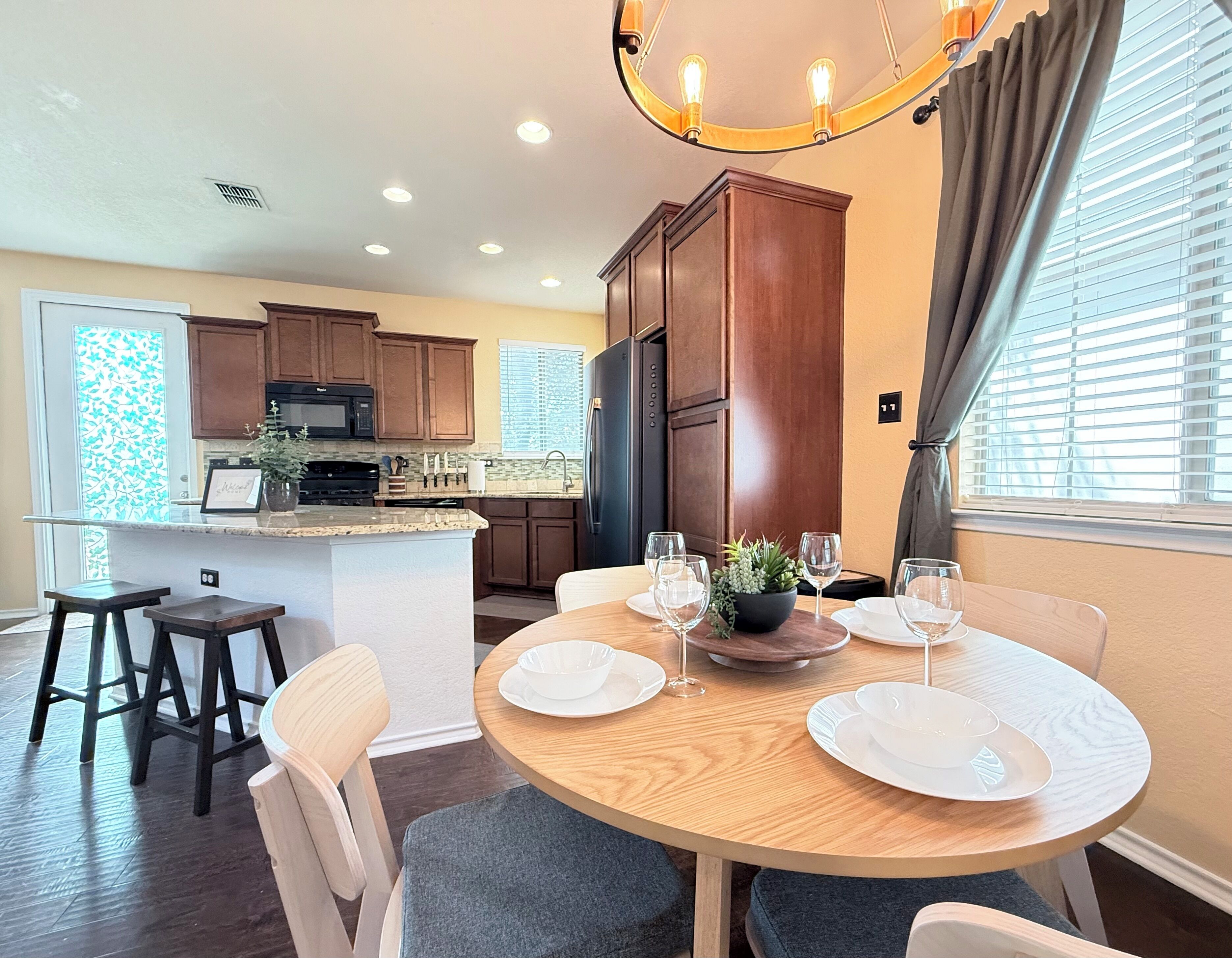 A modern kitchen with dark wood cabinets, a black refrigerator, and a microwave.