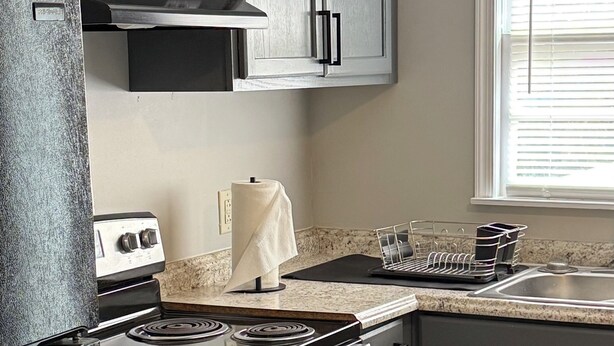 A kitchen with a stove, oven, and cabinets.