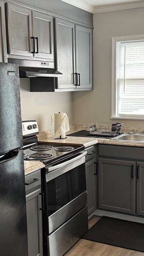 A kitchen with a stove, oven, and cabinets.