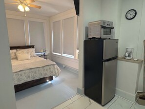A compact hotel room with a bed, a refrigerator, a microwave, and a coffee maker. - Renovated Apartment Downtown HS (Hot Springs)