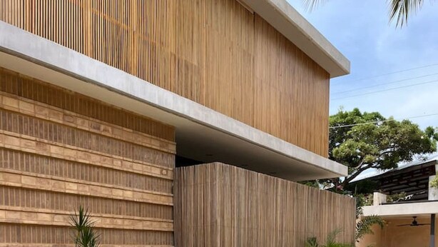 Un bâtiment moderne doté d’une piscine, de lambris en bois et d’un escalier menant à un étage supérieur.