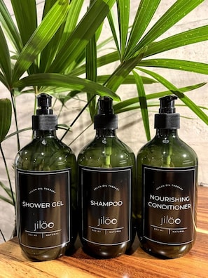 Tres ampolles de productes Jiloo: gel de bany, xampú i condicionador nutritiu, cadascuna amb una capacitat de 500 ml.