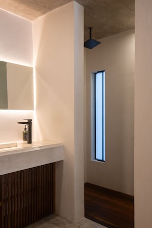 Un bany modern amb un mirall gran, un lavabo i una finestra.