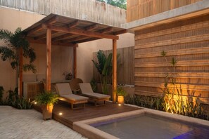 A covered outdoor seating area with two lounge chairs, a small table, and a hot tub. - Jilöo - Beautiful Oasis in Punta Zicatela (5) (Punta Zicatela)
